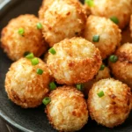 Close-up of air fryer shrimp balls with a golden crispy texture on a clean white plate.
