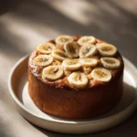 Close-up of a banana cake with a Korean aesthetic, featuring a clean background and natural lighting.
