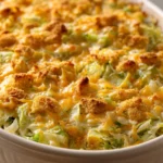 Close-up of a cheesy cabbage casserole with a golden cracker topping, filling the frame.