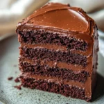 Close-up of a beautifully decorated chocolate cake with rich textures and a clean background.