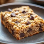 Close-up of chocolate chip oatmeal cookie bars with visible chocolate chips and a golden-brown texture.