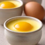 Close-up of classic vanilla custard cups with a smooth, creamy texture and a light golden top.