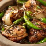 Close-up of Black Pepper Chicken with creamy sauce and herbs on a white plate.