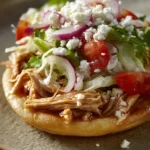 Close-up of chicken sopes with toppings on a clean plate