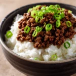 Close-up of a Korean Ground Beef Bowl with rice, vegetables, and sesame seeds.