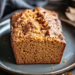 Close-up of pumpkin bread with a golden crust and soft interior, showcasing its texture and color.