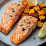 Close-up of air fryer salmon and sweet potatoes with bright, natural lighting.