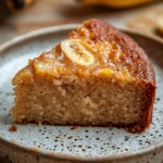 Close-up of a banana cake slice with visible textures and a clean background.