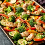 Close-up of chicken stir fry with vegetables on a sheet pan, vibrant and appetizing.