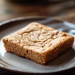 Close-up of gluten free peanut butter cookie bar with a golden crust and rich texture