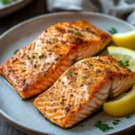 Close-up of deliciously cooked salmon in a Ninja air fryer with a golden crust.