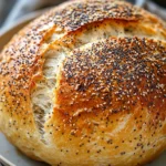 Close-up of no knead bread with everything bagel seasoning on a wooden board.