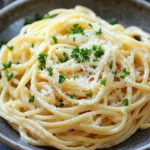 Close-up of one pot creamy garlic noodles with a creamy sauce and garnished with herbs.
