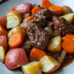 Close-up of slow cooker beef with potatoes and carrots in a warm, inviting setting.